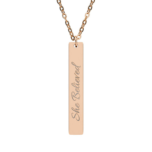 "She Believed" Vertical Bar Necklace - Inspirational jewelry in silver, gold, and rose gold featuring a simple bar pendant with the empowering message "She Believed" engraved on it.